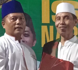 Kurdi Ismail (Kiri) saat menyerahkan bantuan sarung gratis.